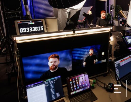 Obrazek do artykułu: „Pracuj na moich plikach”. Jak wymusić na AI, żeby odpowiadała na bazie dokumentów, a nie fantazji. mężczyzna na ekranie monitora, ciemne kolory