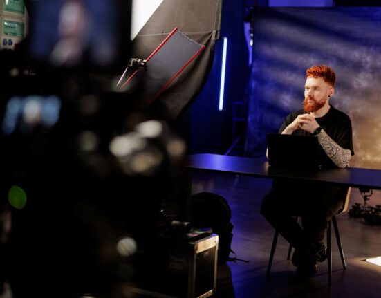 Obrazek do artykułu: 2 reguły, które blokują wyciek danych z narzędzi AI. mężczyzna siedzi przy biurku, tło ciemne